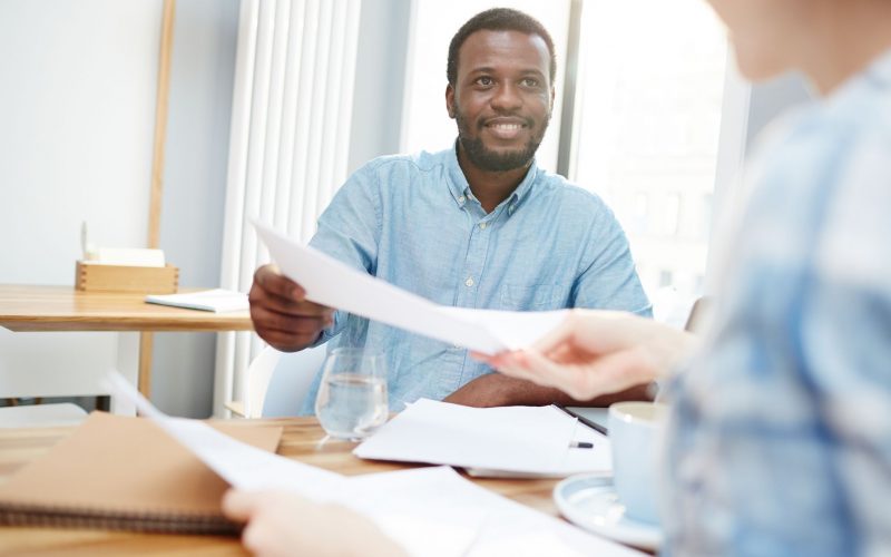 Businessman passing over paper or signed contract to his colleague or secretary